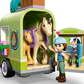 The LEGO® Friends Horse & Baby Foal Trailer by Legos - Toyhouse features a figurine with a helmet, two toy horses, a green trailer with horse-themed decor, and grooming tools—ideal for young horse lovers.