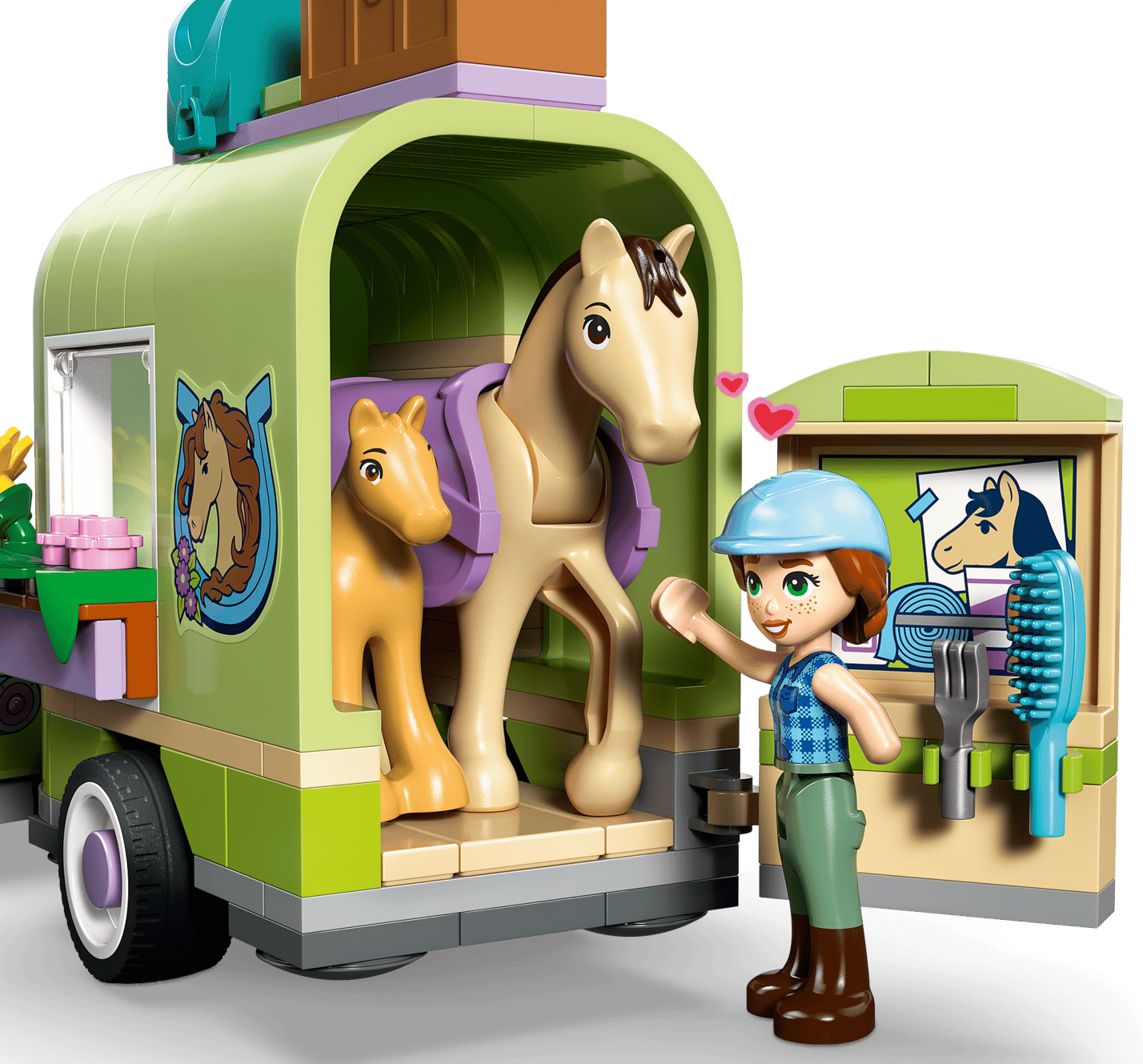 The LEGO® Friends Horse & Baby Foal Trailer by Legos - Toyhouse features a figurine with a helmet, two toy horses, a green trailer with horse-themed decor, and grooming tools—ideal for young horse lovers.