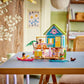 The LEGO® Friends Beach House with Seals by Legos - Toyhouse is shown with figures, a kayak, and animal seals on a table in a cozy, sunlit room featuring natural decor.