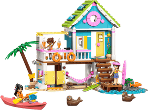 The Legos - Toyhouse LEGO® Friends Beach House with Seals set includes two mini-figures, a kayak, surfboards, seals, beach accessories, and features a sandy base with palm tree and outdoor stairs.
