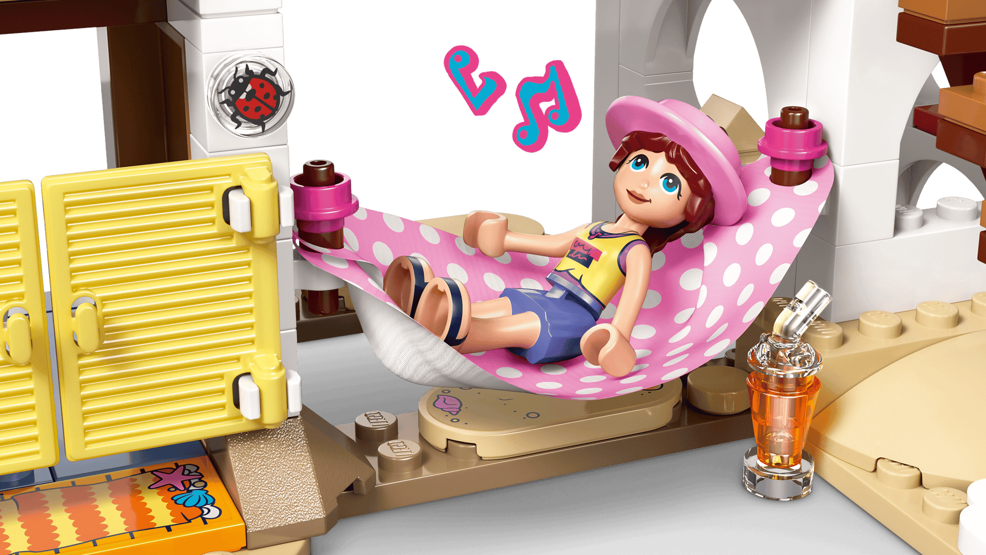 A LEGO® Friends Beach House with Seals by Legos - Toyhouse features figures relaxing on a pink polka-dot hammock with music notes, accessories, and seals—creating a cozy scene perfect for any playhouse set for kids.