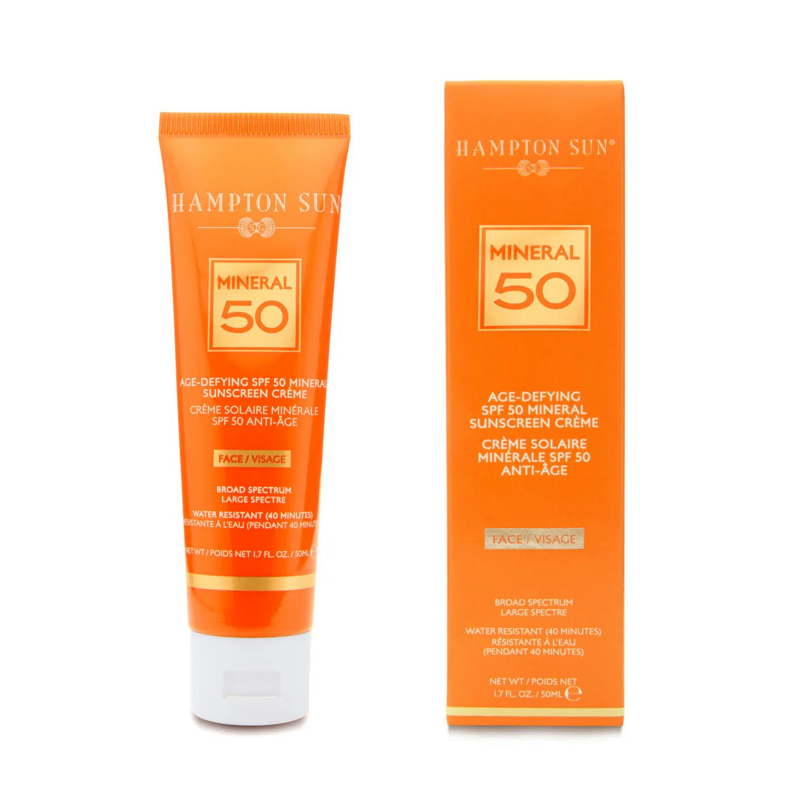 An orange tube and box of Hampton Sun Age Defying SPF 50 Mineral Face Creme for face, with anti-aging benefits and non-nano zinc oxide, both displaying product details in white and gold text.