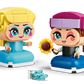 The LEGO® Disney™ Mini Anna & Elsa set by Legos - Toyhouse features two colorful figures with large heads and dresses; one holds a sunflower, while the other has light blue accessories on the ground nearby.