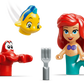 Figures of a red crab, yellow fish, and Ariel with red hair and purple top are shown with a small gray fork in front, inspired by LEGO® Disney™ Ariel's Magical Mini Palace from Legos - Toyhouse.