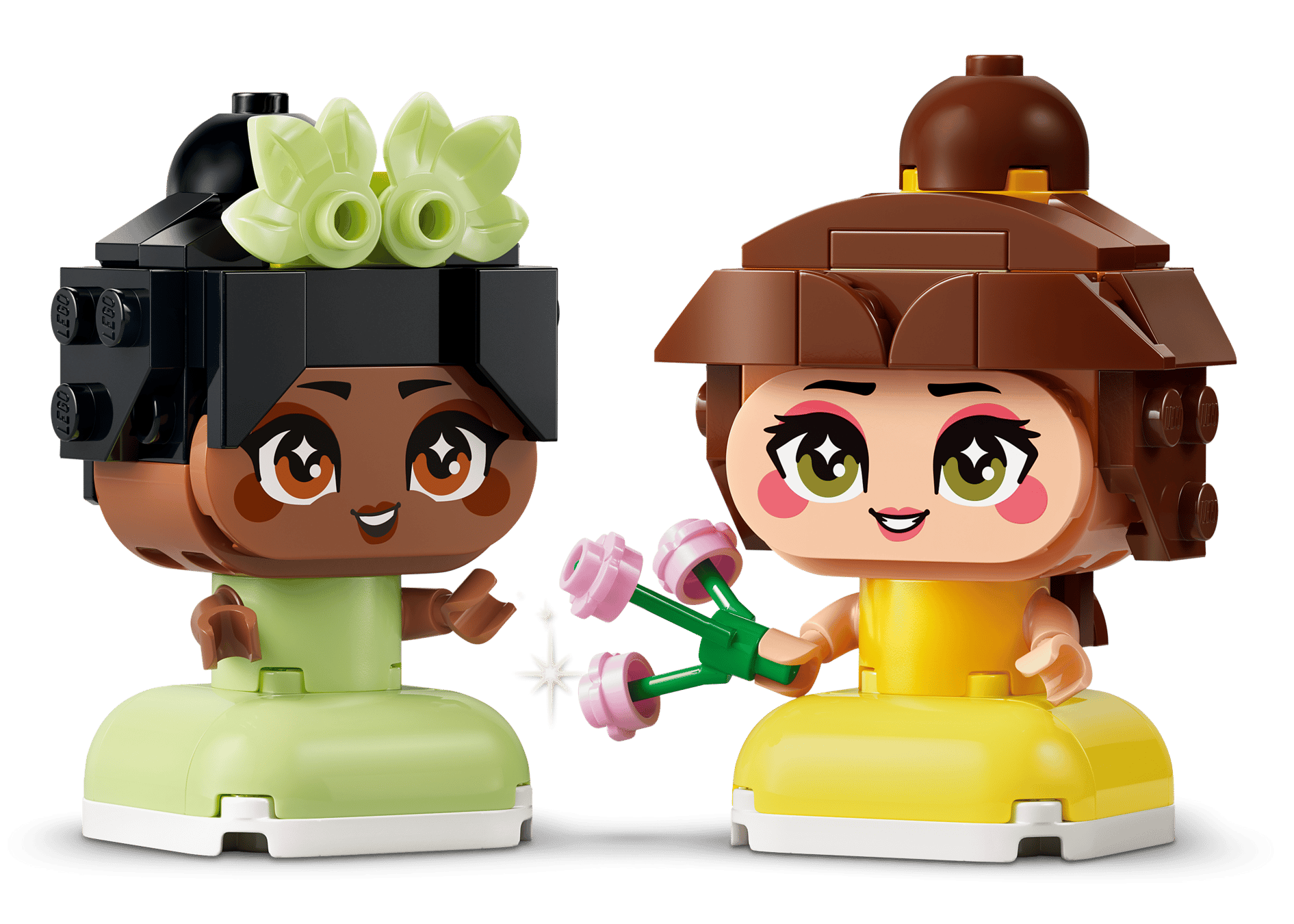 Two LEGO® Disney™ Mini Belle & Tiana with Castle figures from Legos - Toyhouse stand together, smiling in colorful dresses as one holds pink flowers—perfect for imaginative adventures.