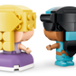 Two block-style figures face each other, one with yellow hair and a purple dress, the other with black hair, a blue headband, and blue outfit—perfect for any Legos - Toyhouse LEGO® Disney™ Mini Jasmine & Rapunzel playset.