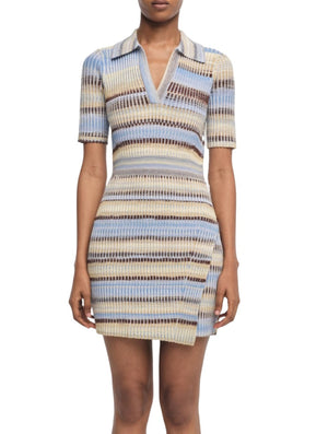 A woman wearing the Simkhai Solana Dress by Simkhai. This short-sleeved, multicolored knit dress with a V-neck and a fitted waist features horizontal stripes in shades of beige, blue, and brown, creating a vibrant pattern that catches the eye.