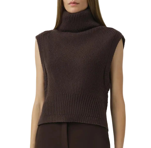 A woman wears the Simkhai Maple Top, a sleeveless brown ribbed turtleneck sweater with a cropped silhouette, paired with brown pants.