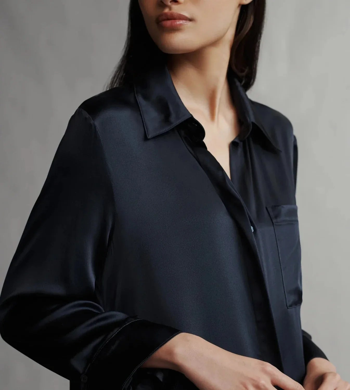 A woman is seen in a partial, close-up view against a plain background, showcasing the TWP Jenny's Silk Gown from TWP.