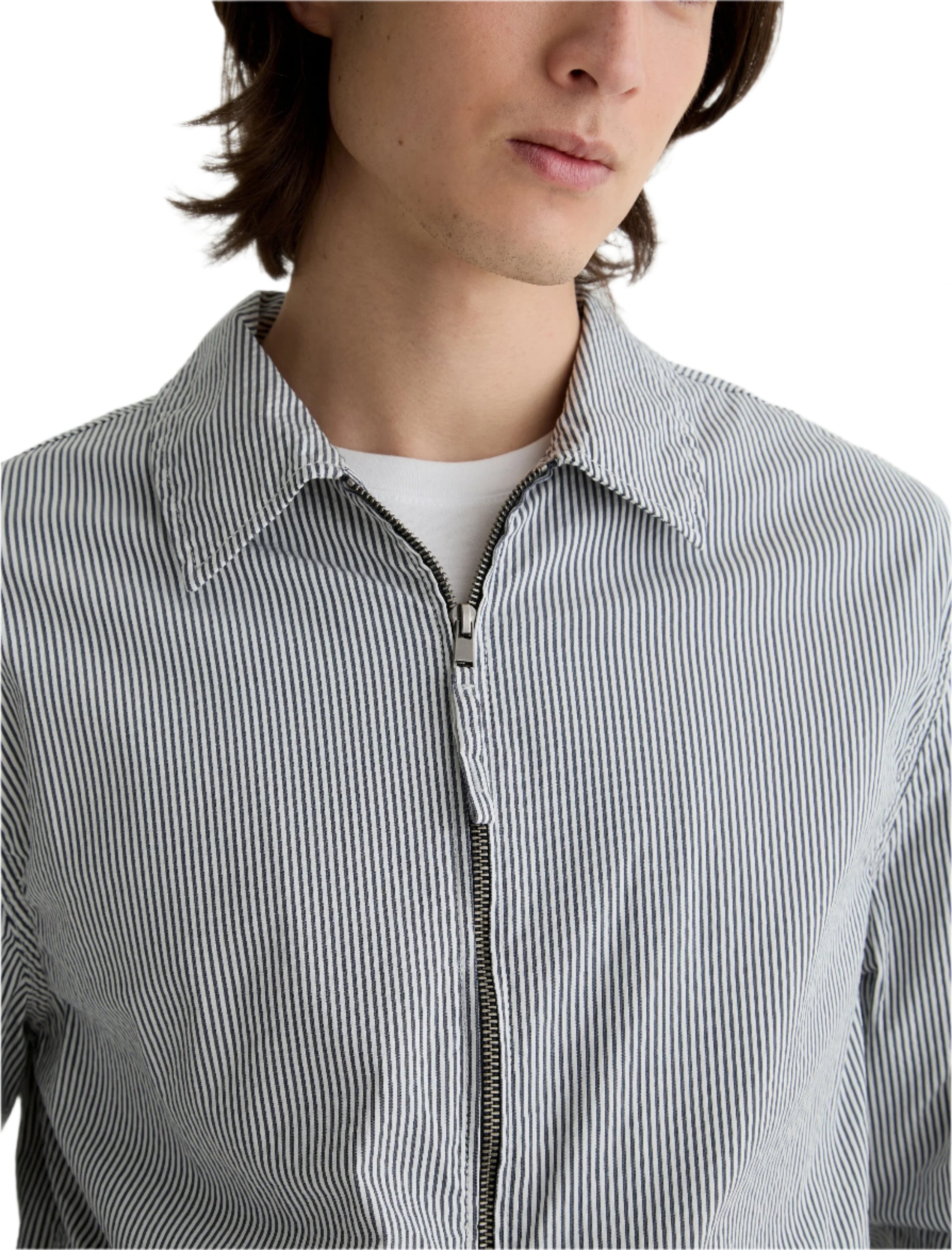 A person shown from the shoulders up wears a white t-shirt under a gray and white AG Jeans Philip Zip Jacket.