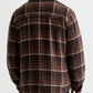 Back view of a person wearing a brown and tan houndstooth Grant Overshirt with a collar.