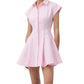 A woman wears the Simkhai Clemmie Mini Dress, a light pink cotton piece with cap sleeves, a collared neckline, and a flared skirt.