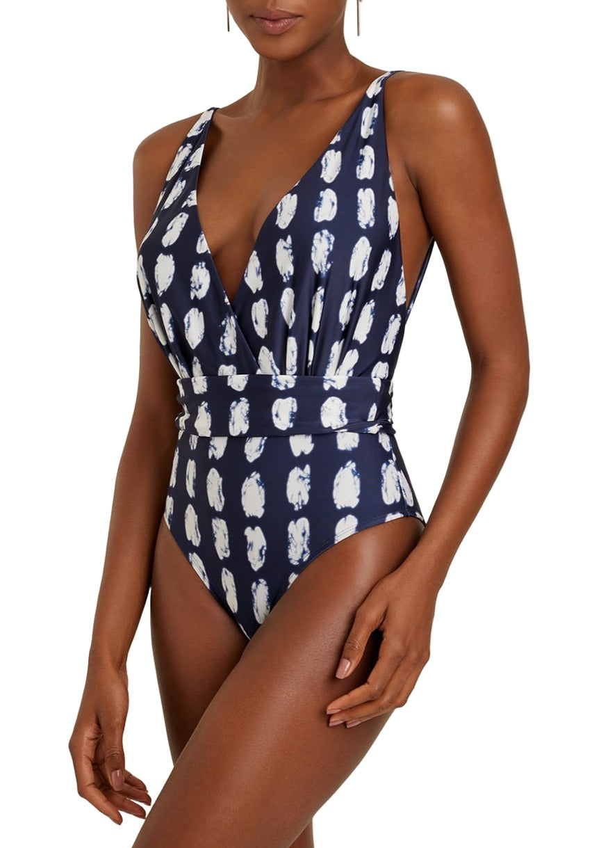 A person is wearing the Lenny Niemeyer Rec Cachecoeur One Piece from the brand Lenny Niemeyer, a navy blue one-piece swimsuit made with BIO Lycra, showcasing a white abstract pattern and a deep V-neck design.