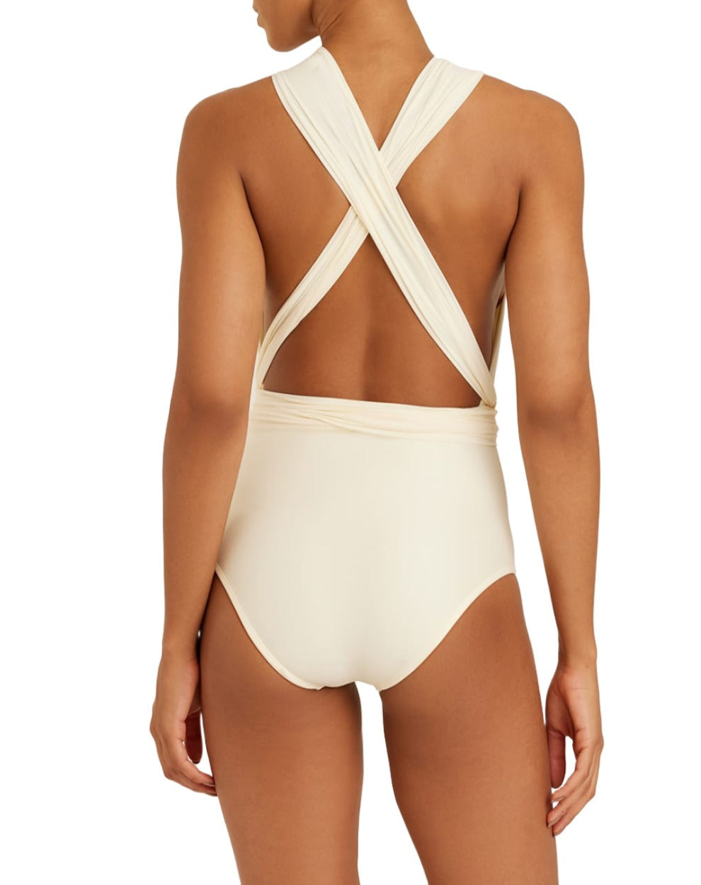 A person stands with their back to the camera, showcasing the Lenny Niemeyer Chic One Piece, a light-colored sleeveless swimsuit with a cross-back design. This stylish piece from Lenny Niemeyer provides biodegradable UPF 50+ UV protection, perfect for eco-conscious sun lovers.