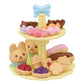 The Calico Critters Sweets Party Set features a two-tiered yellow tray filled with assorted toy desserts—animal-shaped pastries, tarts, candies, and cupcakes adorned with a blue bow—making it perfect for imaginative playtime or pairing with your favorite tea accessories.