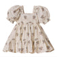 The Noralee Girls' Louella Dress features short puff sleeves, a cream floral print, a square neckline, and a charming tiered skirt for a vintage-inspired look.