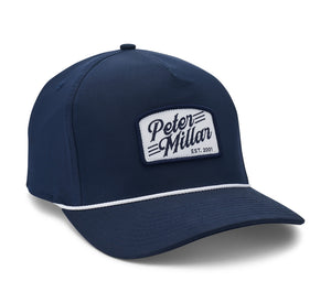 The Peter Millar Est. Clubhouse Rope Hat is a classic navy cap with a white "Peter Millar EST. 2001" patch and crisp white trim above the brim for stylish contrast.