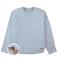 The Boys’ Teo Jersey Tee by Gingersnaps is a light blue long-sleeve shirt with subtle urban style, featuring a small embroidered brown dachshund on the lower front corner, as shown in a close-up inset.
