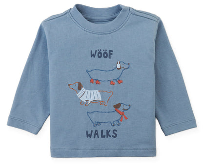 Gingersnaps Baby Boys’ Myron Graphic Tee is a blue long-sleeve shirt featuring a playful “WOOF WALKS” design with three illustrated dachshunds stacked vertically on the front.