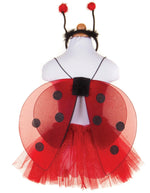 A child-sized mannequin displays the Great Pretenders Glitter Ladybug Set, featuring a red costume with black spots, glittery ladybug wings, a tutu skirt, and a headband with two antennae.