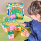 A child arranges colorful Eeboo Dinosaur Picture Blocks on a table, with the product box labeled "Dinosaur Picture Blocks" visible in the background.