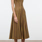 A woman stands against a plain background in heeled sandals, wearing the Staud Wells Midi Cotton Poplin Dress—a sleeveless, calf-length style featuring vertical brown and yellow stripes that showcase the effortlessly polished signature silhouette of Staud.