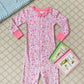 A pink Baby Girl's Noelle's Night Night sleeper by The Beaufort Bonnet Company is laid out on a carpet next to three children’s books, including some from the Winnie-the-Pooh series.