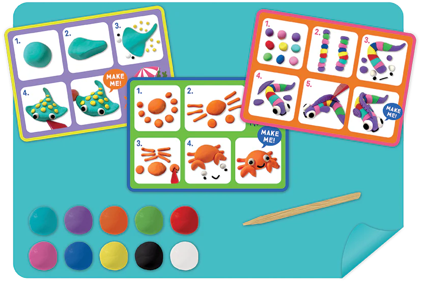 Floss and Rock’s Clay & Play - Ocean set includes three illustrated instruction cards, colored clay discs, a wooden tool, and a blue mat to inspire creativity with ocean-themed modeling fun.