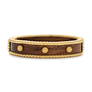 The Berry Small Hinged Bangle by Juliska Capucine De Wulf features a dark brown wooden band with gold-toned rope edges and three round gold studs on the front, making it perfect for stacking with your favorite golden jewelry.