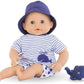 The Corolle Bebe Bath Doll, wearing a purple hat and striped shirt with a whale print, sits beside a blue toy whale—an adorable water-play companion, shown against a white background.