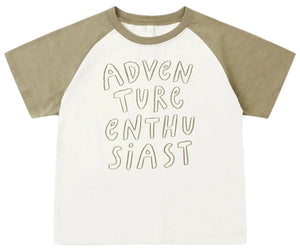 The Rylee & Cru Baby Boys’ and Boys’ Raglan Short Sleeve Tee features khaki raglan sleeves and a white cotton jersey body, with “ADVENTURE ENTHUSIAST” displayed in bold handwritten-style lettering on the front.