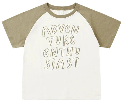 The Rylee & Cru Baby Boys’ and Boys’ Raglan Short Sleeve Tee features khaki raglan sleeves and a white cotton jersey body, with “ADVENTURE ENTHUSIAST” displayed in bold handwritten-style lettering on the front.