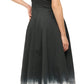 A woman is shown from behind, facing right, wearing Staud's Wells Dress, a sleeveless black and white tie-dye cotton poplin piece, against a plain background.