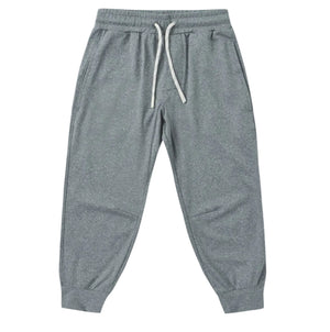 The Boys’ Century Tech Jogger by Rylee & Cru, featuring a gray relaxed fit, elastic waistband with white drawstring, side pockets, and cuffed ankles, is displayed laid flat on a white background.