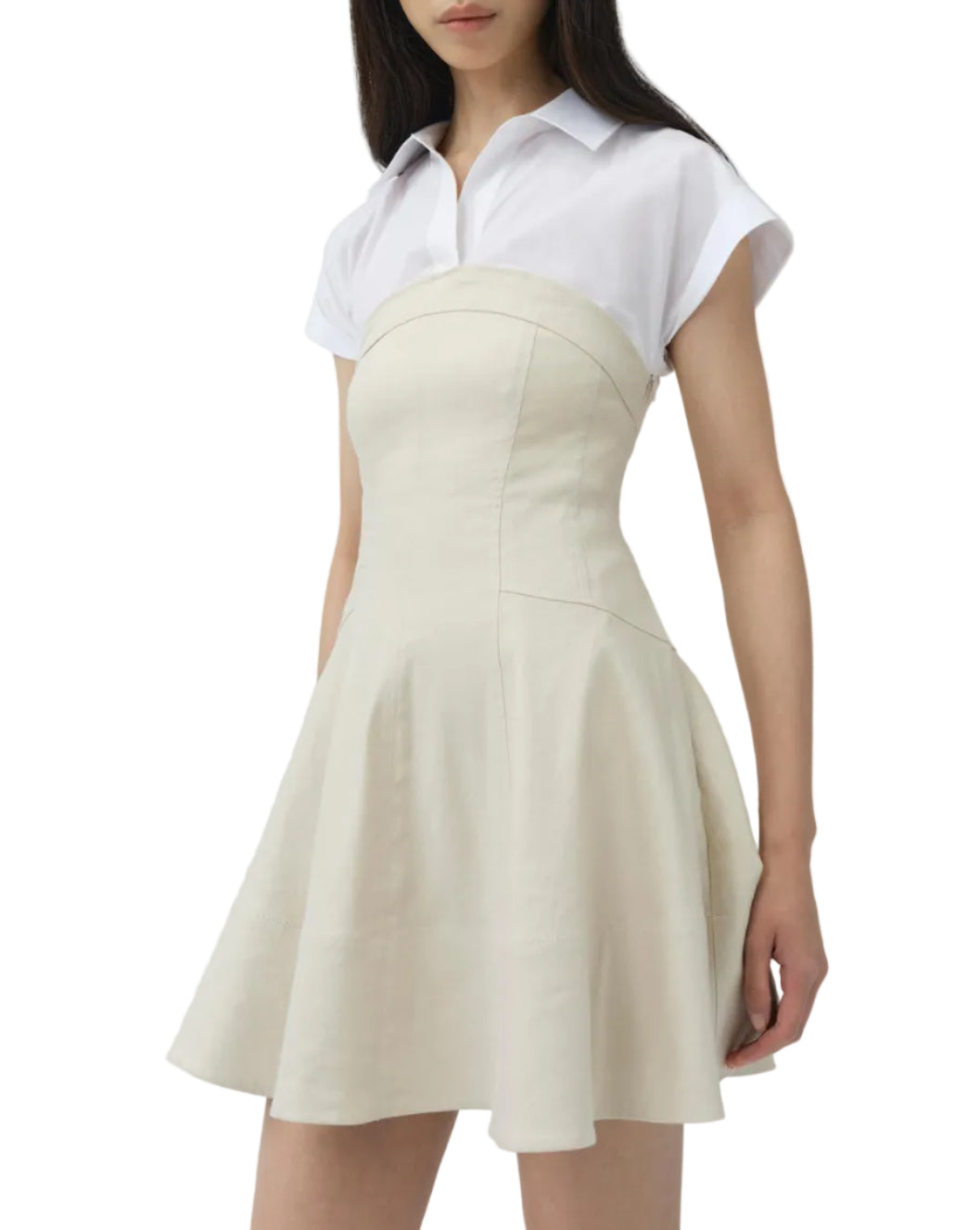 A woman wears the Simkhai Sundae Linen Mini Dress, featuring a structured bodice and flared skirt, layered over a short-sleeved white collared shirt.