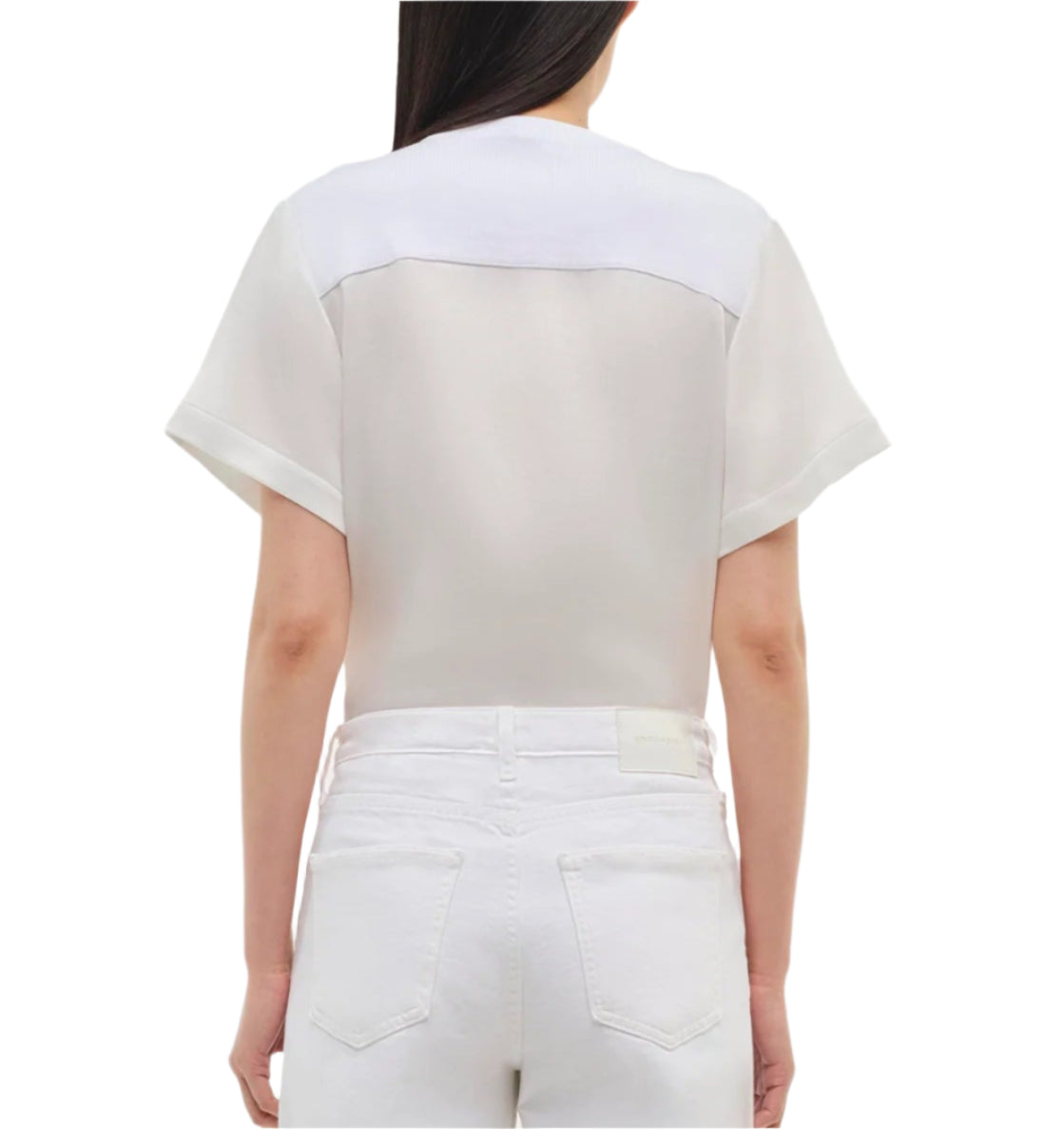 A person is shown from the back against a plain background, wearing the Simkhai Addy Satin T-Shirt in white with matching white jeans.