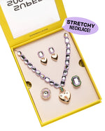 The Super Smalls Lavender Haze Mega Jewelry Set comes in a yellow box with a stretchy purple necklace, earrings, rings, and a heart-shaped pendant, plus a "STRETCHY NECKLACE!" label.