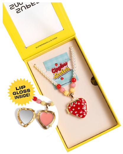 The Super Smalls Strawberry Surprise Lipgloss Locket is a heart-shaped kids’ necklace with a pearl and bead chain in a yellow box. Open the locket to reveal two glossy Strawberry lip gloss shades for fun beauty play.