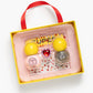 The Super Smalls Paint it Heartfelt Mini Nail Kit includes two yellow-capped bottles, a heart gem, glittery polish, and heart nail stickers, all in a tray with a red handle.