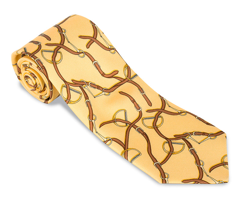 Crafted in the USA by R. Hanauer, the elegant R. Hanauer Stirrup Tie showcases a yellow hue with a brown and silver bit pattern and is rolled at one end. Measuring 57 inches in length, it offers both style and sophistication.