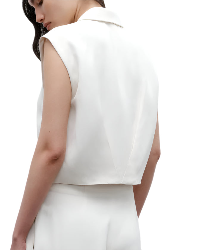 A woman is shown from the back wearing the TWP Katie Cropped Tailored Vest in white coated viscose linen with matching white pants, set against a plain white background.
