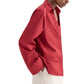 A person wears the Deep V Relaxed Shirt by TWP, crafted from Italian superfine cotton in Karanda Red, paired with off-white pants and standing against a plain background.