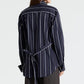 Back view of the TWP The Night We Met Stripe Shirt, a navy blue long-sleeved button-down with thin vertical white stripes and a self-tie waist detail.