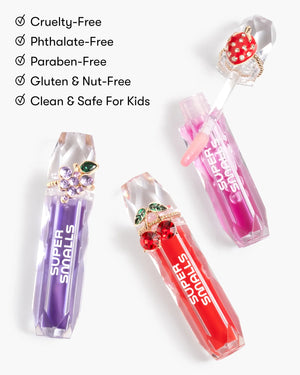 Three jewel-inspired lip glosses from Super Smalls’ Gloss it Rainbow Lip Gloss Ring Set, in purple, pink, and red—cruelty-free, phthalate-free, paraben-free, gluten- and nut-free, and safe for kids.