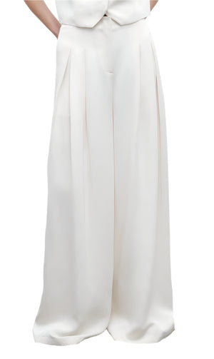 A person models the TWP Drew Pant—high-rise, wide leg, pleated, and crafted from European flax linen—against a plain background.