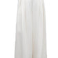 A person wears TWP's Drew Coated Viscose Linen Pant—cream-colored, high-rise wide leg trousers with pleats and pockets; only the upper body is partially visible.