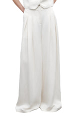 A person wears TWP's Drew Coated Viscose Linen Pant—cream-colored, high-rise wide leg trousers with pleats and pockets; only the upper body is partially visible.