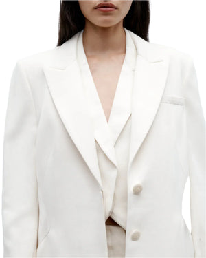 A model wearing the Perfect Boyfriend Blazer by TWP over a white top, shown from shoulders to waist against a plain background.