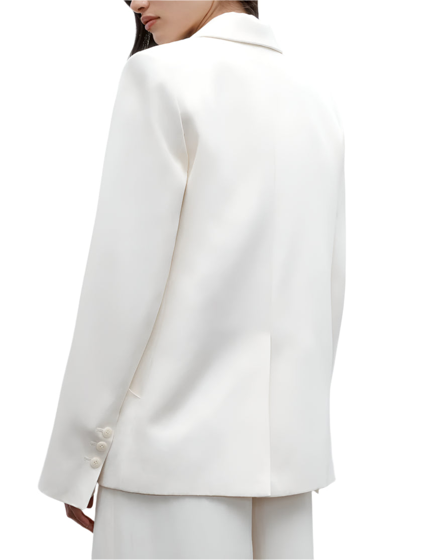 A person is shown from the back against a white background, wearing the TWP Perfect Boyfriend Blazer in white with matching trousers.