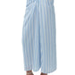 Lower body shown wearing the Simkhai Liorra Draped Midi Skirt in oxford blue, paired with white heeled sandals and a coordinating cropped top.